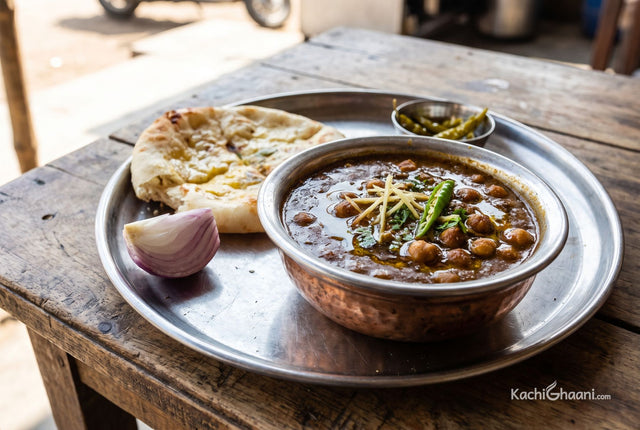 Dark glossy chickpea curry topped with ginger juliennes and green chillies, served with bhature