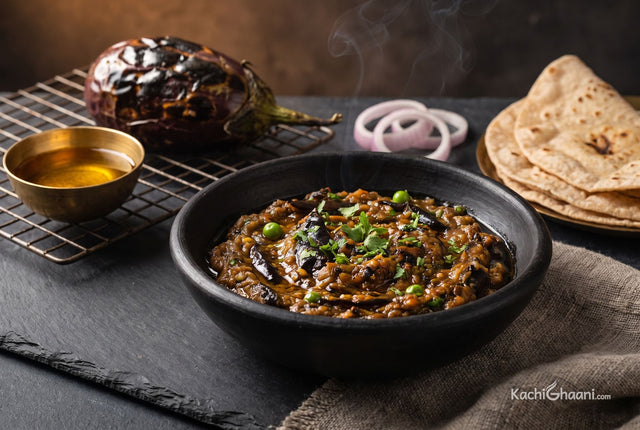 Smoky mashed brinjal glistening with mustard oil, topped with coriander in a black clay bowl