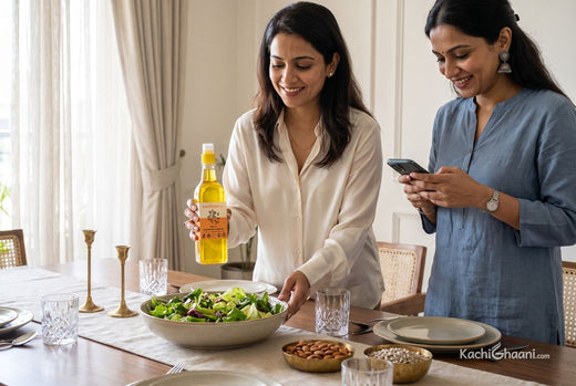 Woman dressing a salad with almond oil as her friend checks a nutrition panel, choosing vitamin E foods for lunch