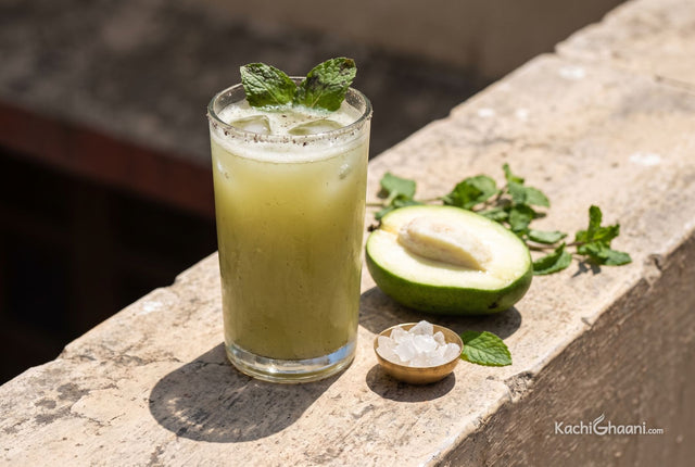 Aam Panna, a tall glass tumbler of aam panna on a sun-bleached stone parapet