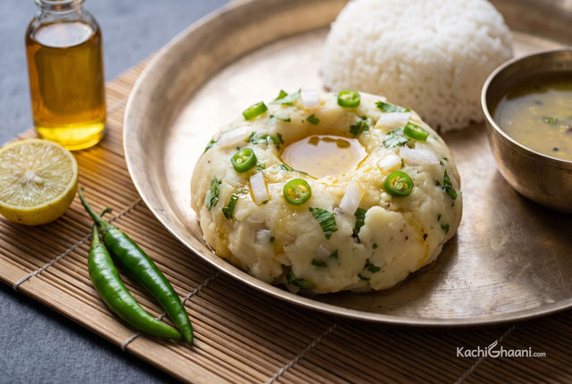 Aloo Pitika, a rough hand-shaped mound of pale creamy mashed potato, glistening faintly with raw mustard oil