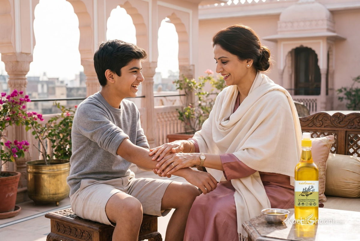 Mother massaging sesame oil onto her son's arms on a sunny Jaipur terrace, the best body oil for winter beside a silver katori