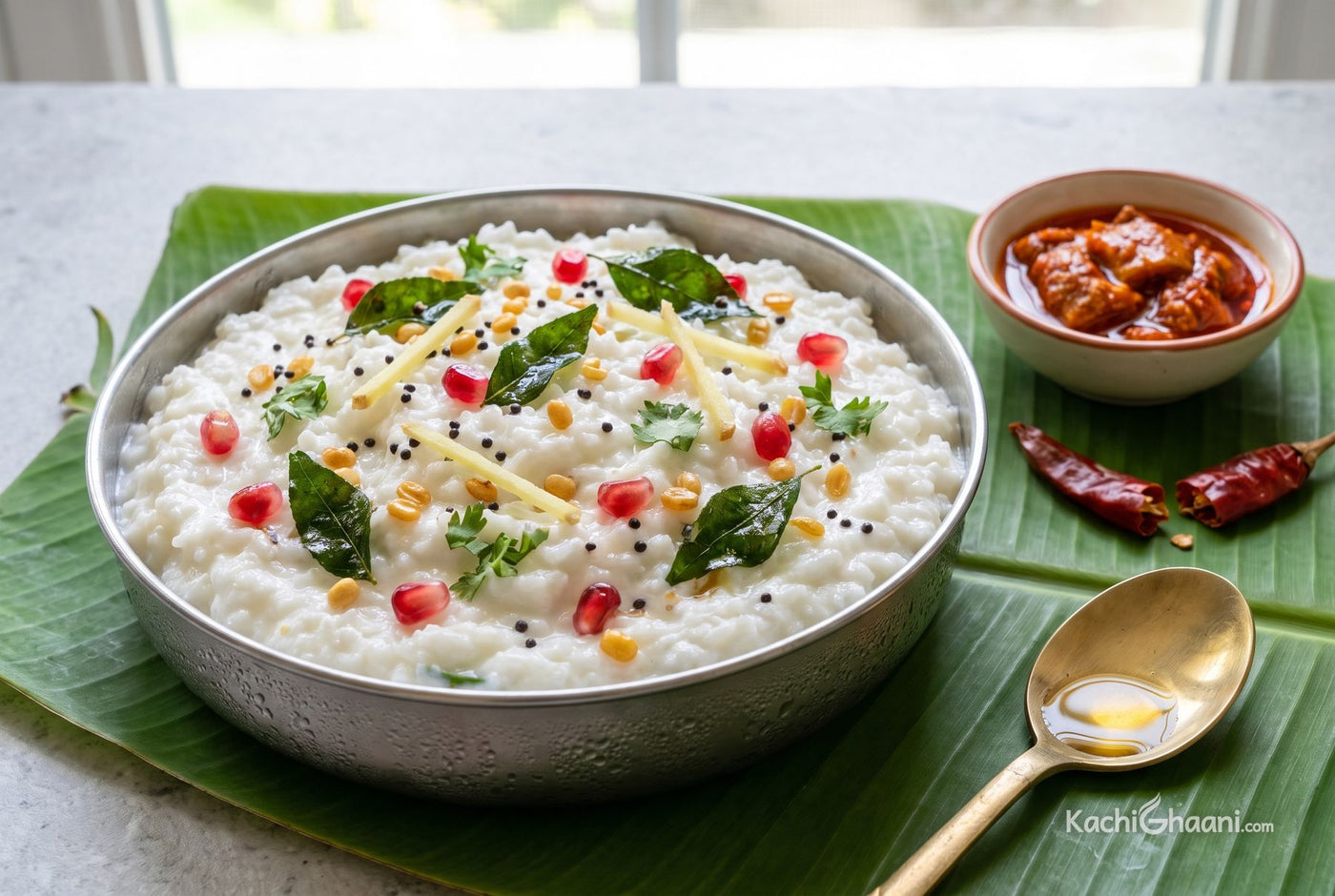 Curd Rice, cool white curd rice heaped in a shallow steel bowl, soft and slightly loose, with black mustard seeds