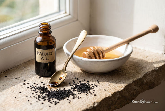 Kalonji oil with honey, a small dark glass bottle of kalonji oil beside a shallow white ceramic bowl of pale amber honey with a
