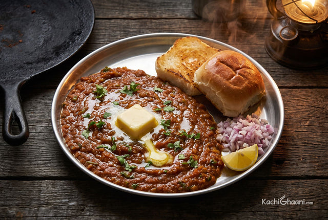 Pav Bhaji, a deep red-brown mashed vegetable bhaji glossy with melted fat in a wide steel plate