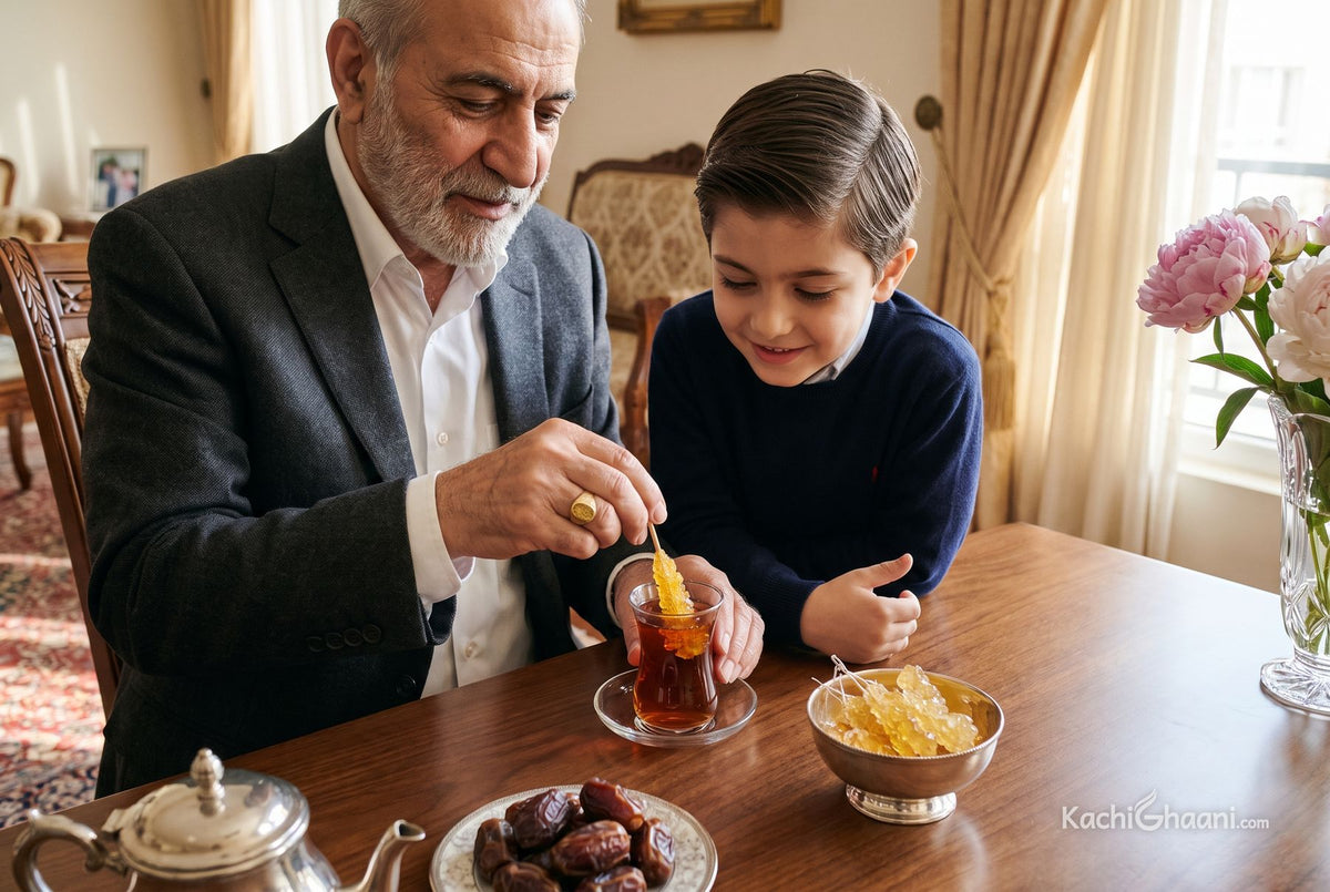 Iranian grandfather stirring saffron nabat rock sugar into a glass of tea as his grandson watches, dhaga mishri in a silver bowl